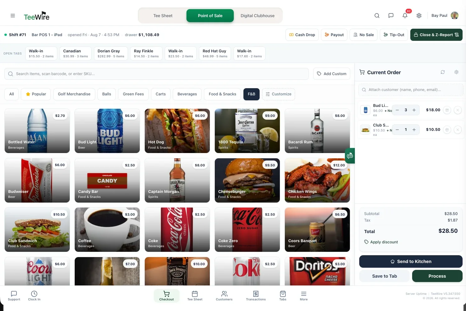 The TeeWire register on a bar station, with the food and beverage category selected. Seven tabs are open across the top, each showing the name it was started under, what it has run to and how many items are on it, from a $14.50 two item tab to a $282.99 five item one. The product grid below covers beer, spirits, soft drinks and food with a photo and a price on every tile, and the current order down the right side holds three Bud Lights at $18.00 and a club sandwich at $10.50, with a $28.50 total, a discount control, and actions to send the order to the kitchen, save it to a tab or take payment.